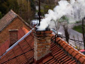 A rooftop chimney with smoke coming out