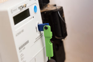 An electricity prepayment meter with a green prepayment key inserted.
