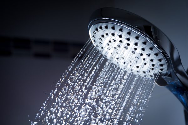 Close up of a showerhead with water coming out