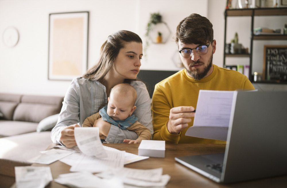 A couple and their baby looking at their estimated bill