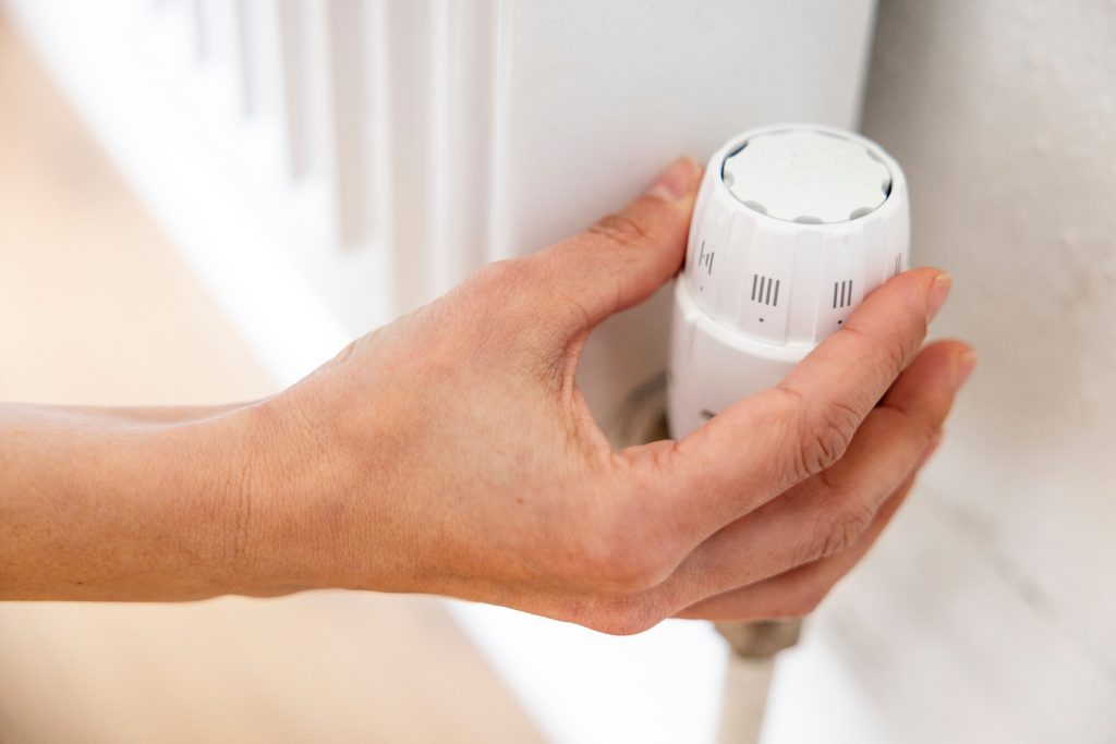 Householder adjusting a Thermostatic Radiator Valve